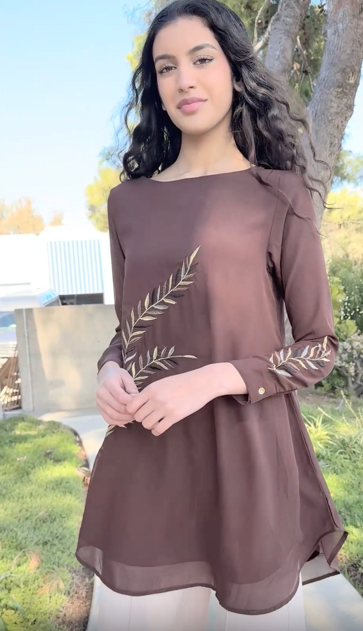 Woman wearing Baraka tunic in Cocoa while walking outside.