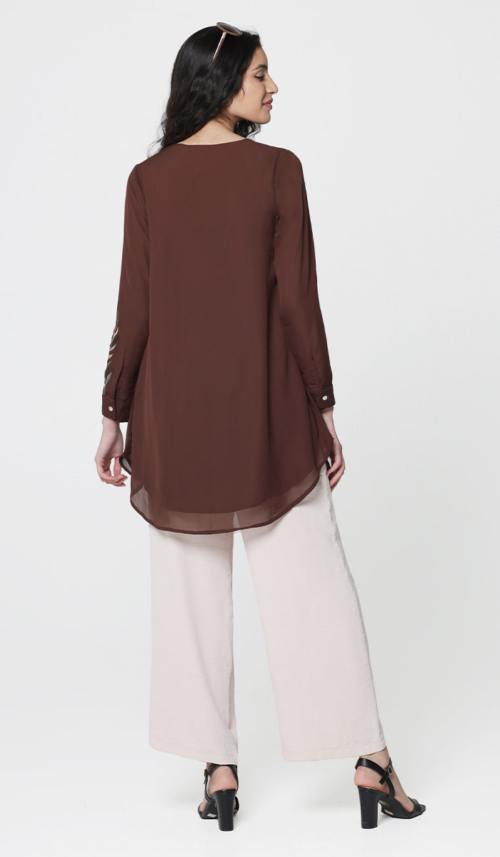 Back view of Baraka tunic in Cocoa with white pants and heels.