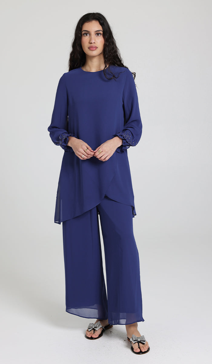 Woman wearing Seema tunic in Blue with pants and sandals.