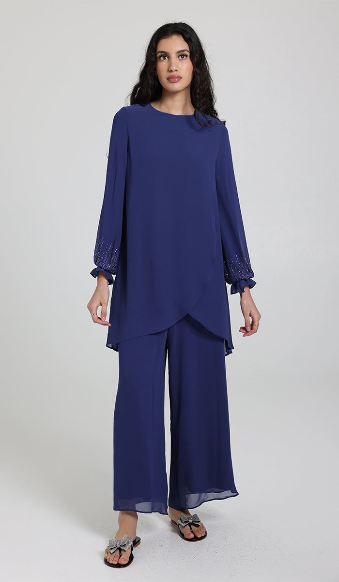 Woman wearing embellished Seema tunic in Blue with pants and sandals.