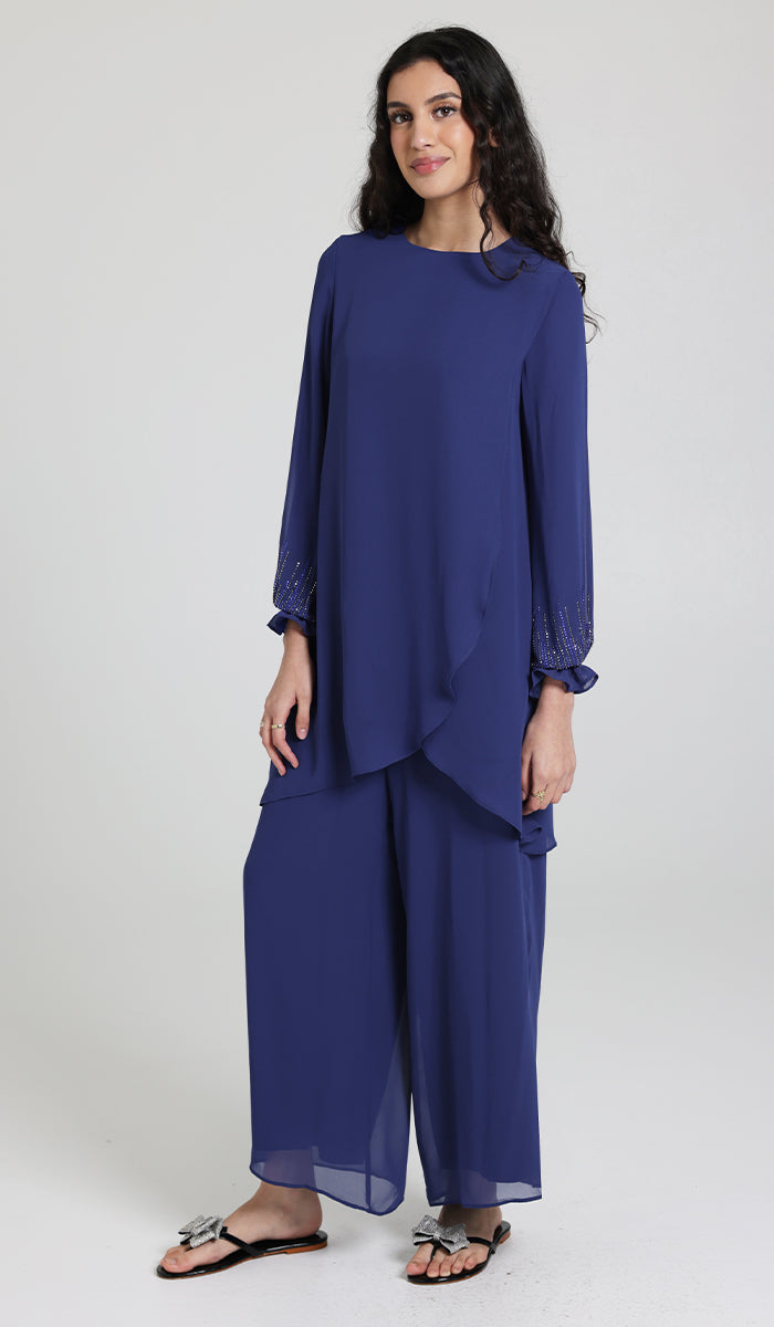 Woman wearing modest Seema tunic in Blue with Blue pants and sandals.