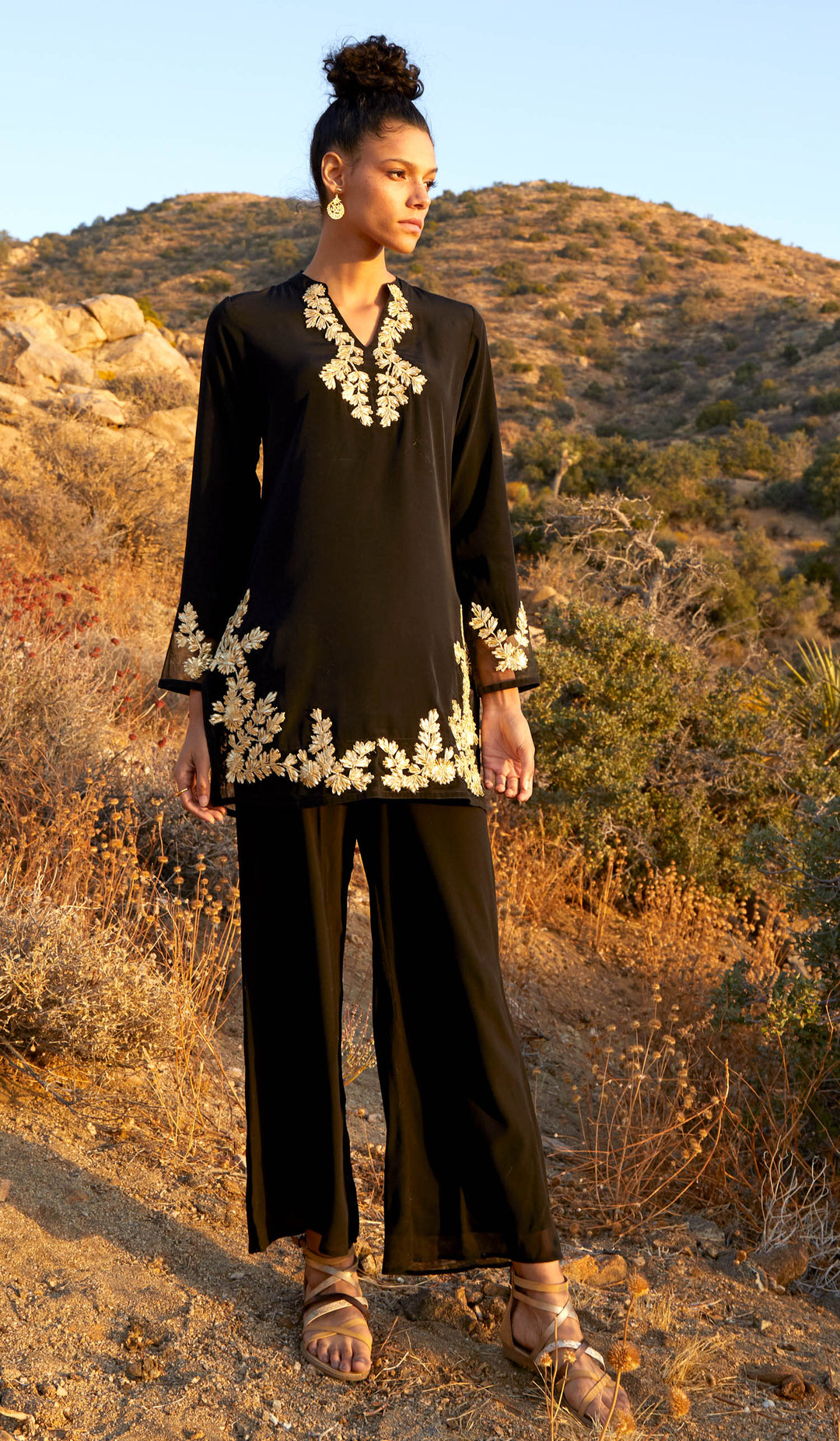 Full body view of model wearing Mahnaz Gold Embellished Modest Tunic in Black with black pants.
