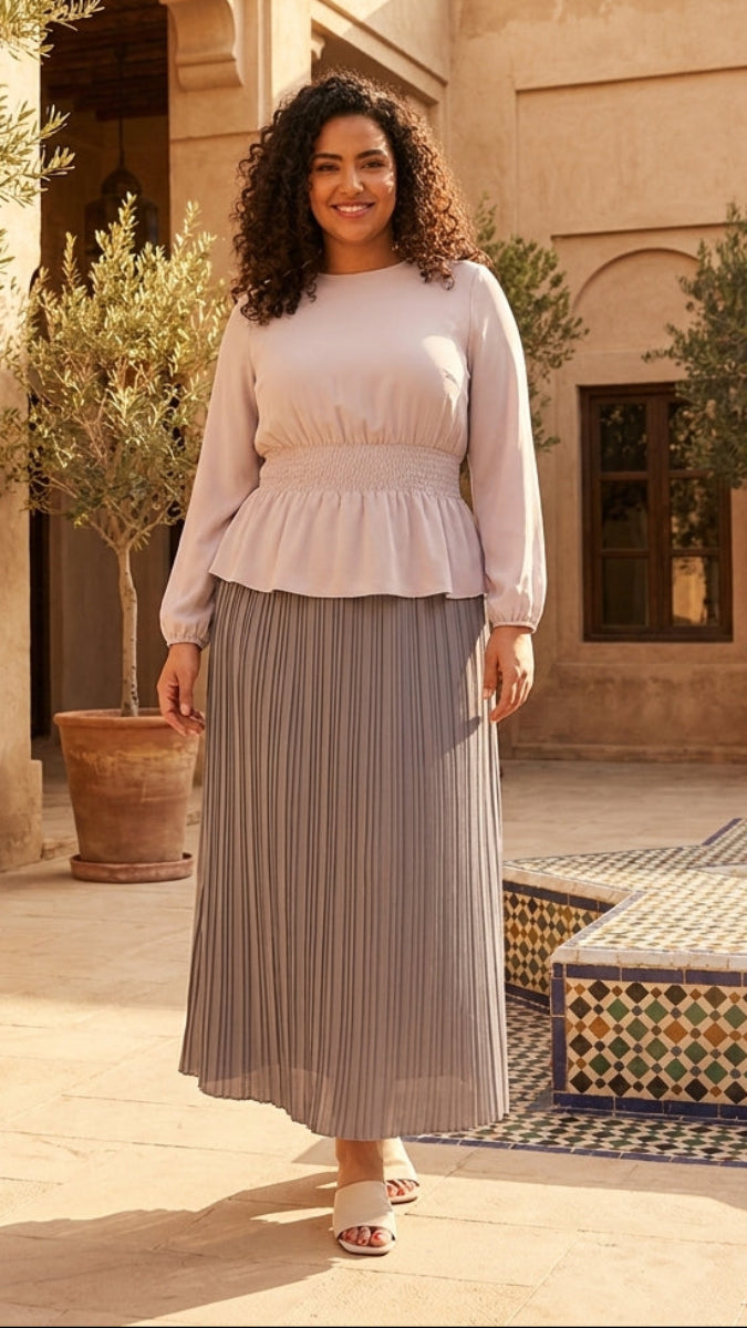 Woman standing in a courtyard with potted plants and a building in the background
