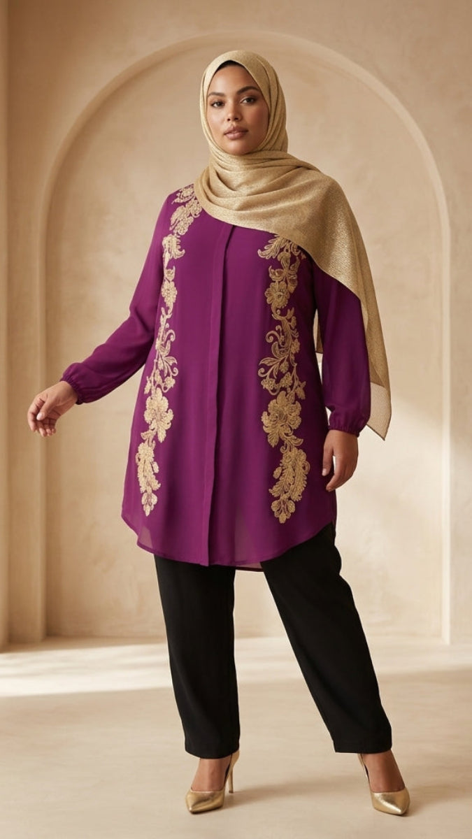 Woman wearing a purple top with gold embroidery and black pants in a beige interior setting