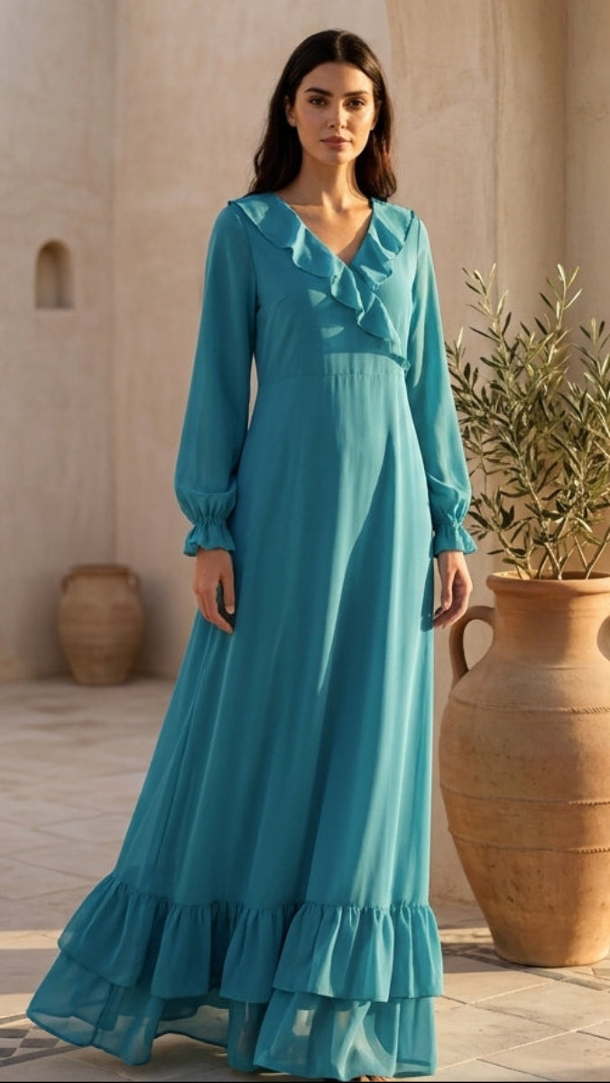 Woman in a turquoise dress standing in a desert setting with arches and vases.