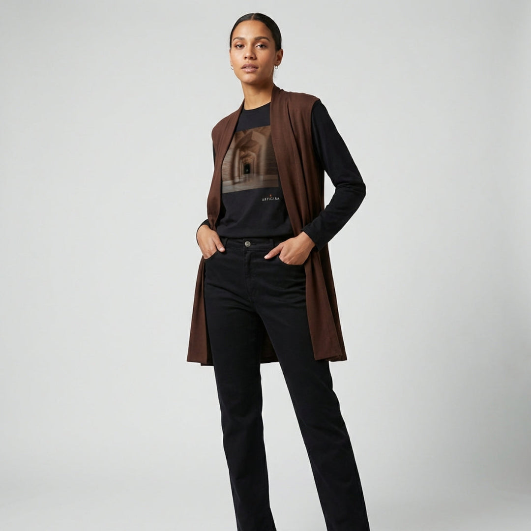 Person wearing a brown cardigan over a black shirt with a graphic design, standing against a plain background.
