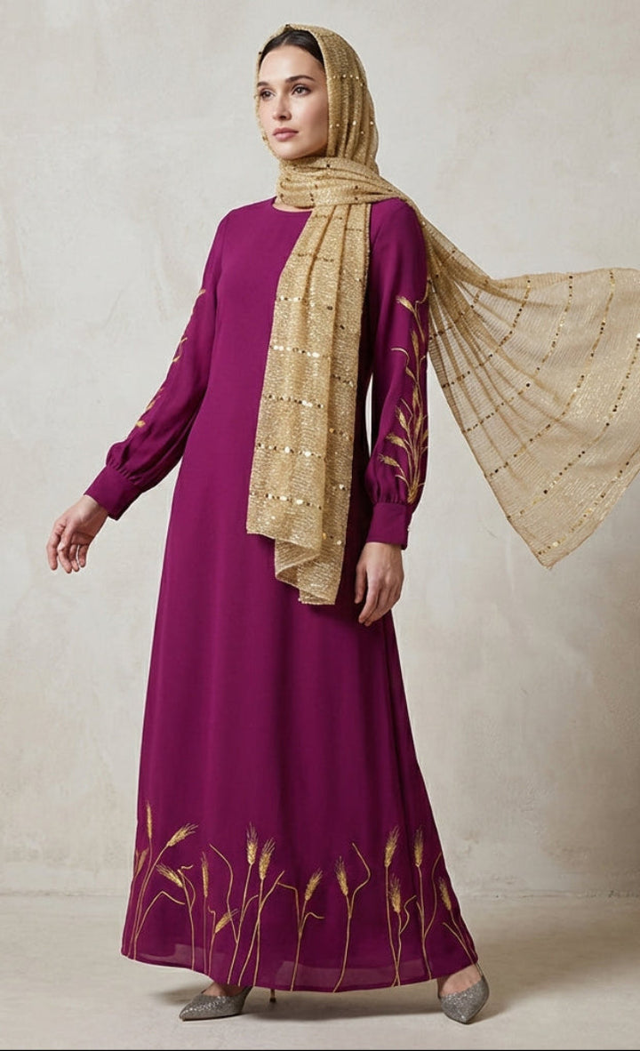 Woman wearing a purple dress with gold embroidery and a matching gold hijab against a neutral background.