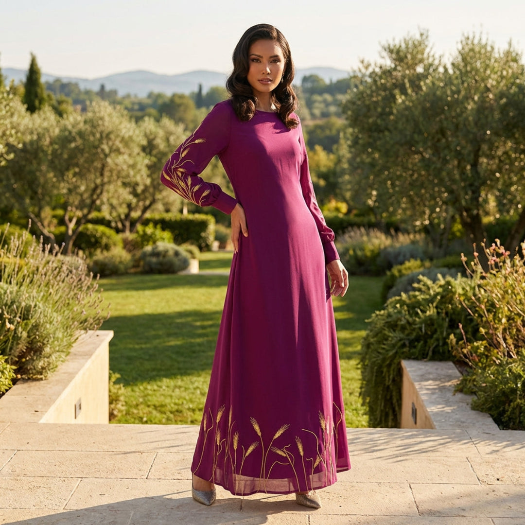 Woman in a long purple dress standing in a garden with trees and grass in the background