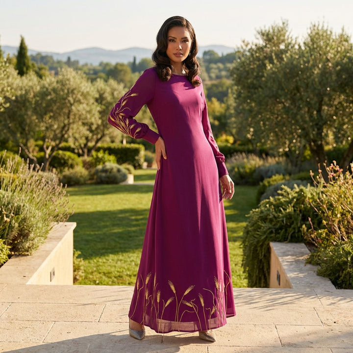 Woman in a long purple dress standing in a garden with trees and grass in the background