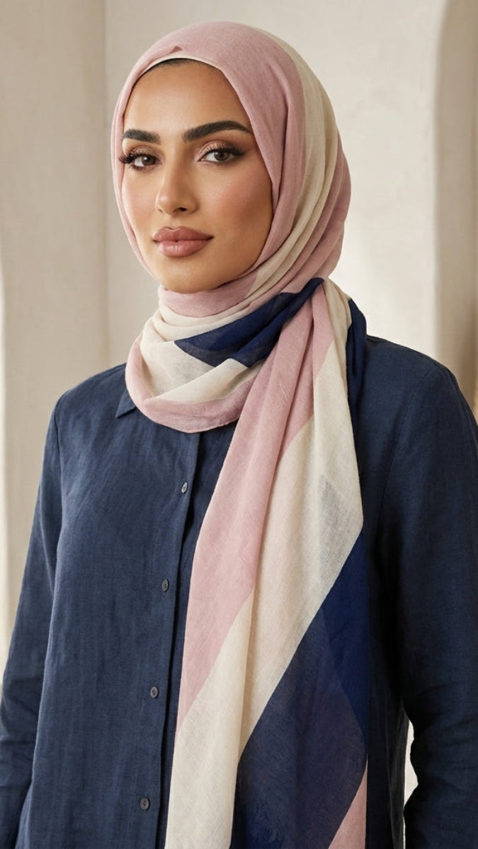 Woman wearing a hijab with a neutral color palette in a softly lit room.