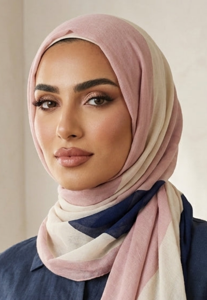 Woman wearing a hijab with a neutral color palette in a softly lit room.