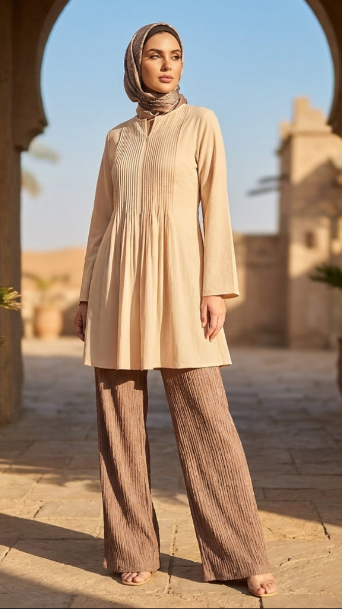 Woman in beige outfit standing in a sunlit archway with desert landscape