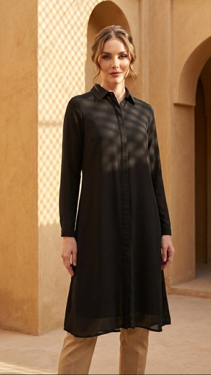 Woman in a black dress standing in a sunlit architectural setting
