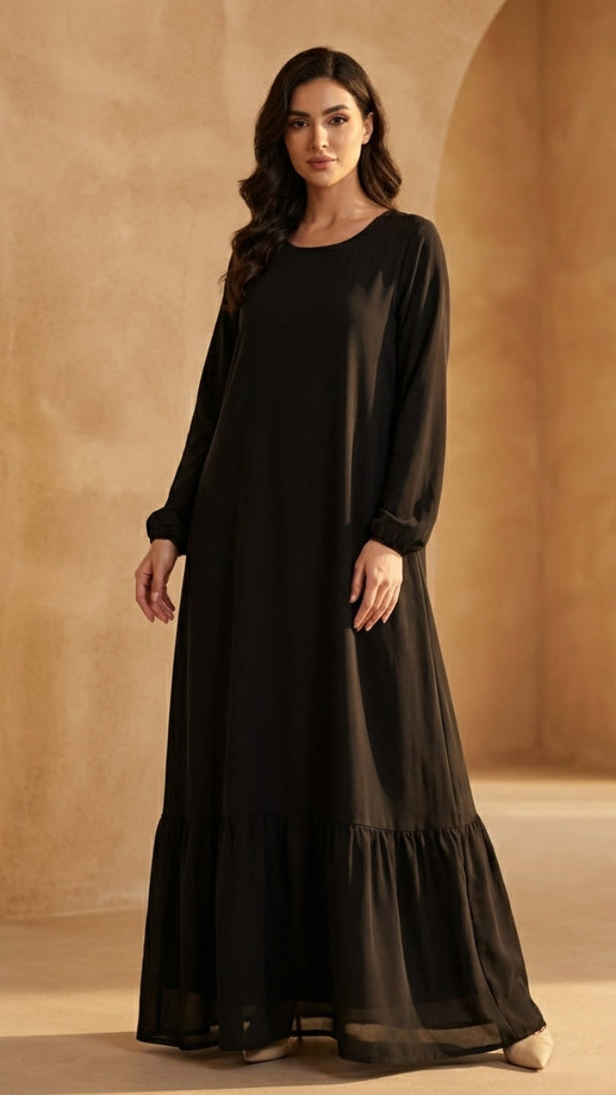 Woman wearing a black dress in a warm-toned architectural setting