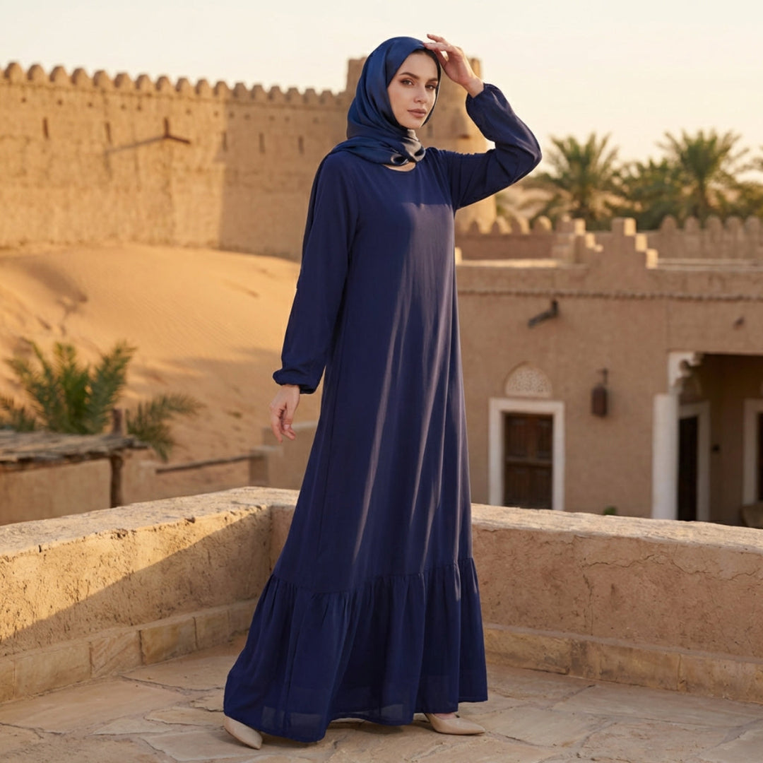 Woman in a blue dress standing on a rooftop with desert landscape in the background