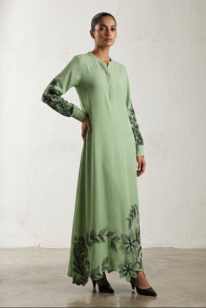 Woman wearing a green dress with floral patterns in a studio setting