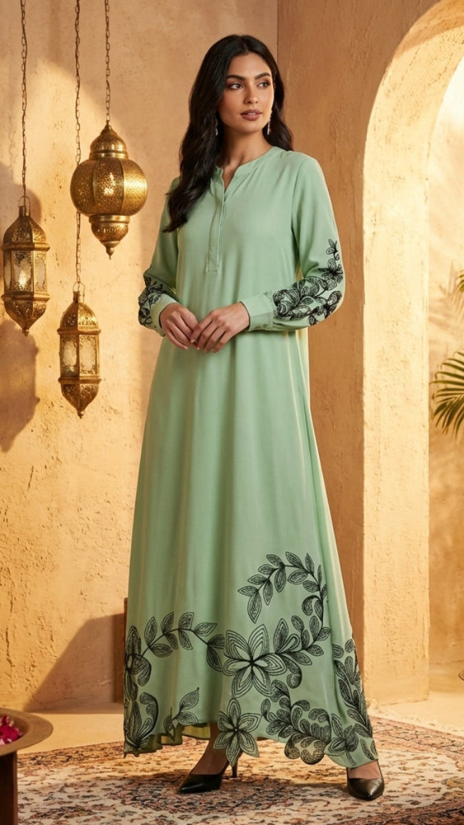 Woman in a light green dress with floral embroidery standing in a decorated room with lanterns and plants.