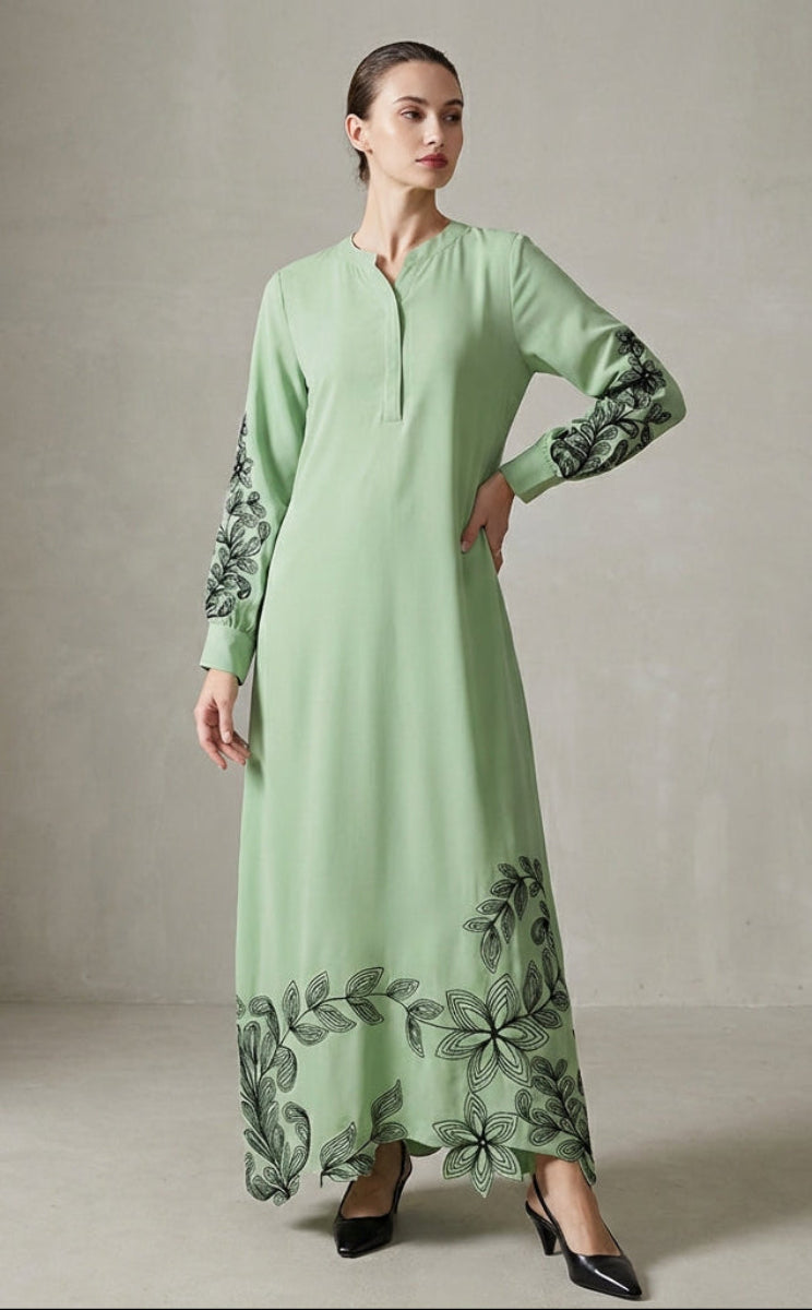 Light green dress with floral embroidery on sleeves and hem, worn by a model against a neutral background.