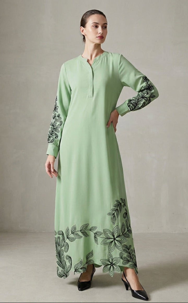Light green dress with floral embroidery on sleeves and hem, worn by a model against a neutral background.