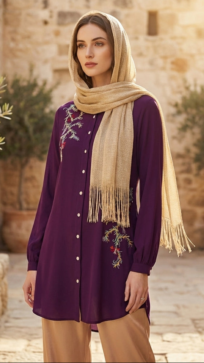 Woman wearing a purple embroidered dress with a beige scarf in an outdoor setting.