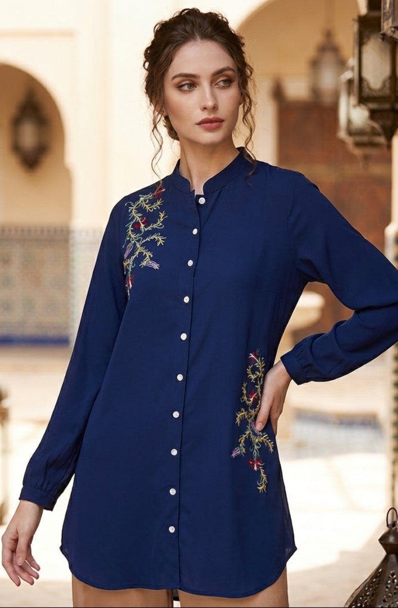 Woman wearing a blue embroidered dress in an ornate setting