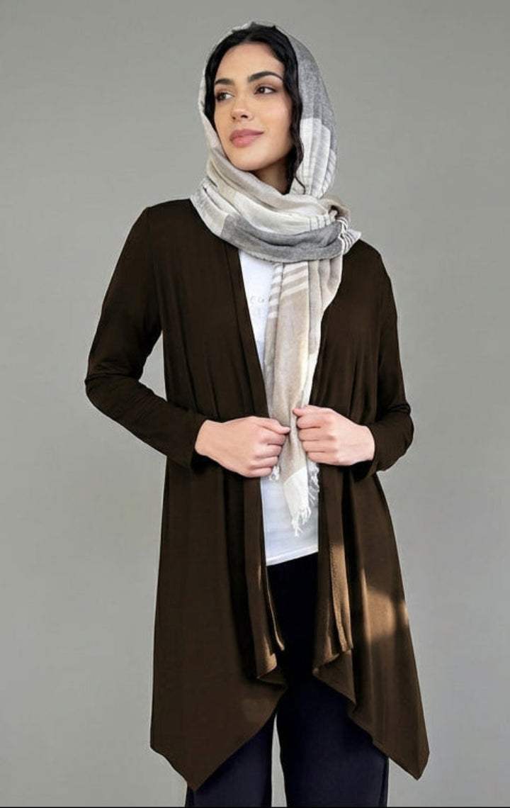 Woman wearing a brown cardigan and scarf on a gray background
