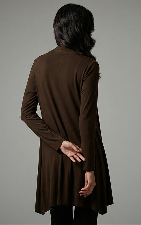 Person wearing a brown long-sleeve top against a gray background