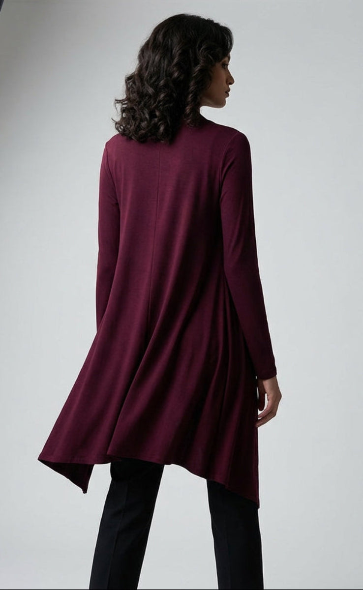Person wearing a burgundy dress in a photo studio setting