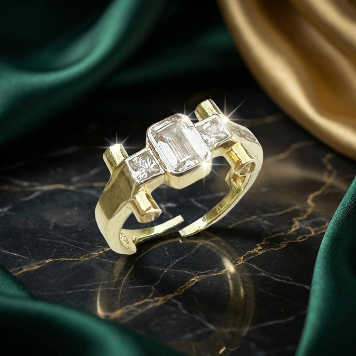 Gold ring with three diamonds on a dark marble surface