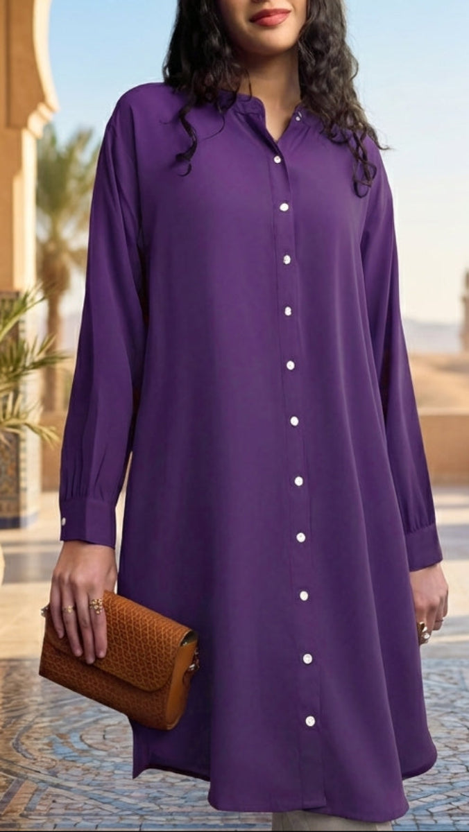 Woman in a purple dress standing in an outdoor setting with arches and plants.