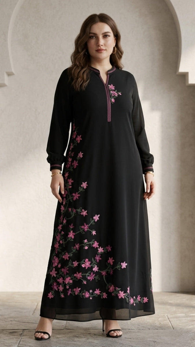 Woman wearing a black dress with pink floral embroidery in a neutral setting