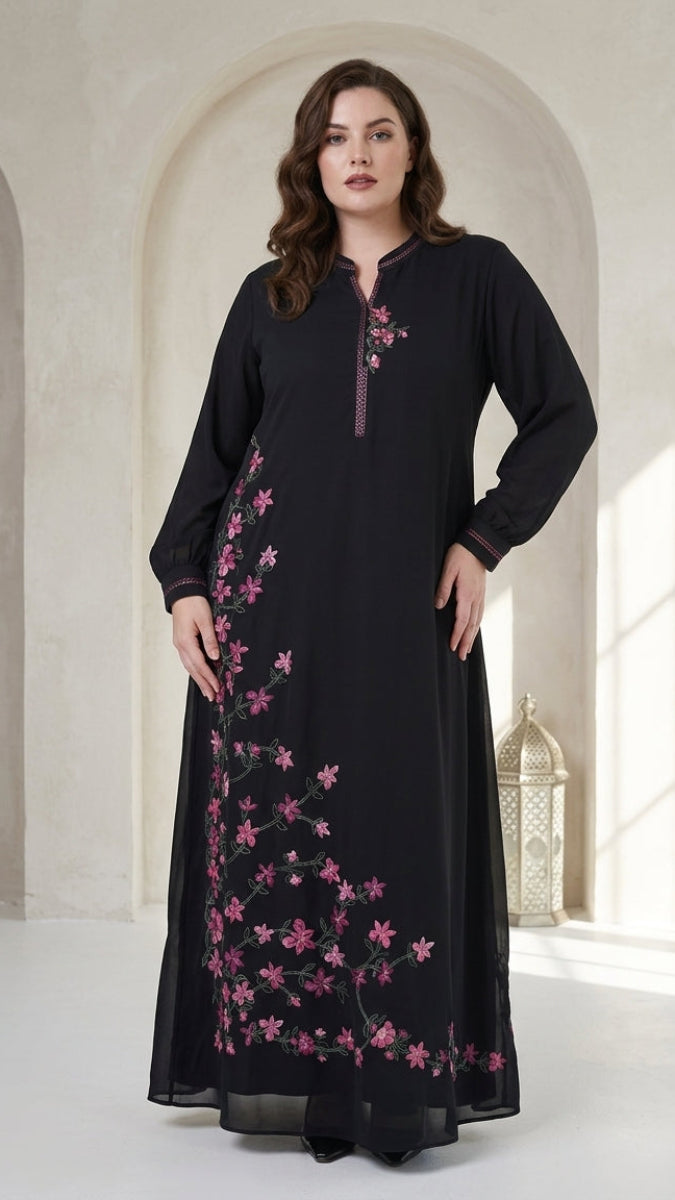 Woman wearing a black dress with pink floral embroidery in an elegant interior setting.