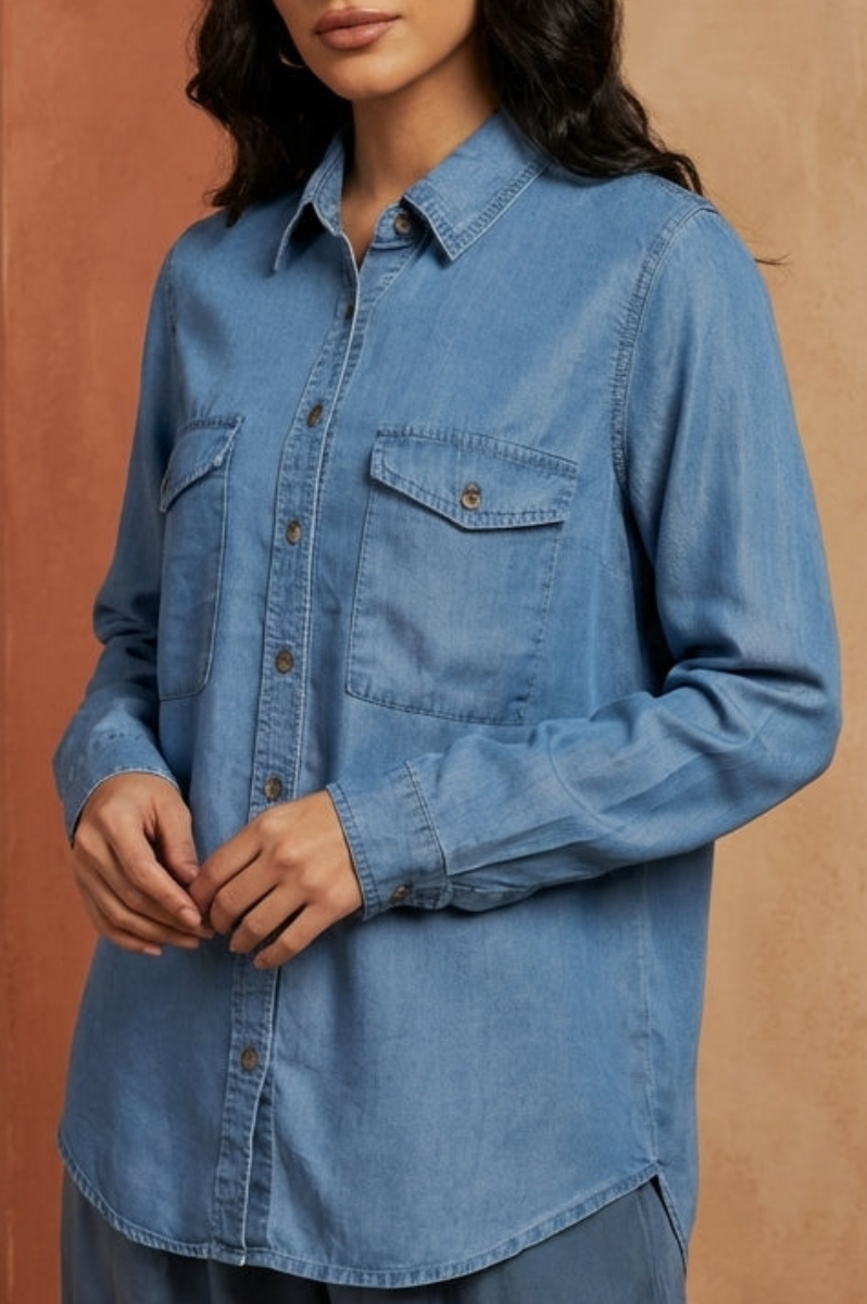 Woman wearing a blue denim shirt in a warm-toned architectural setting