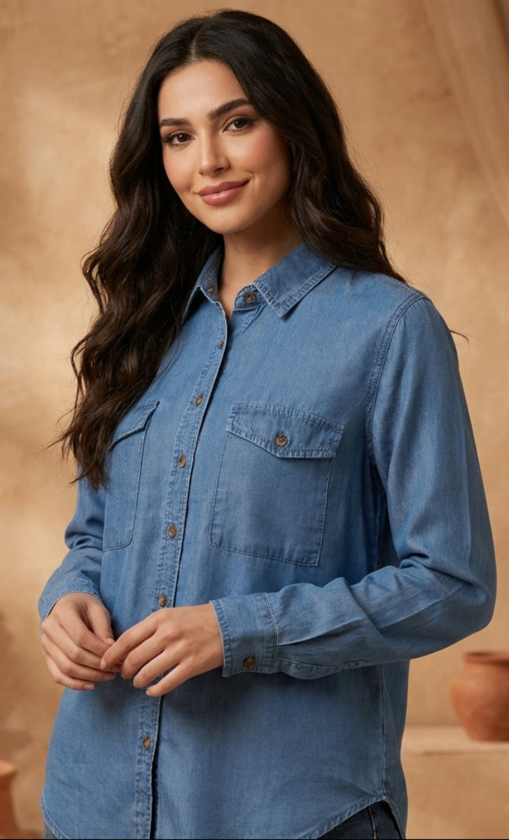 Woman wearing a blue denim shirt standing in front of a warm-toned background with decorative elements.