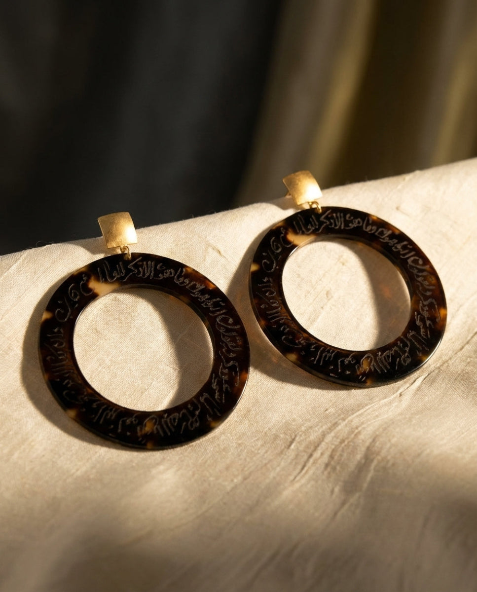 Tortoiseshell hoop earrings on a marble surface