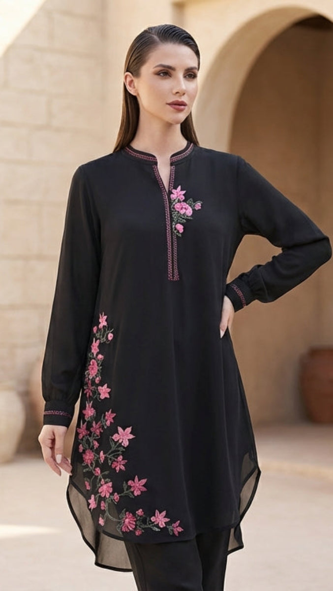 Woman wearing a black embroidered dress in an architectural setting