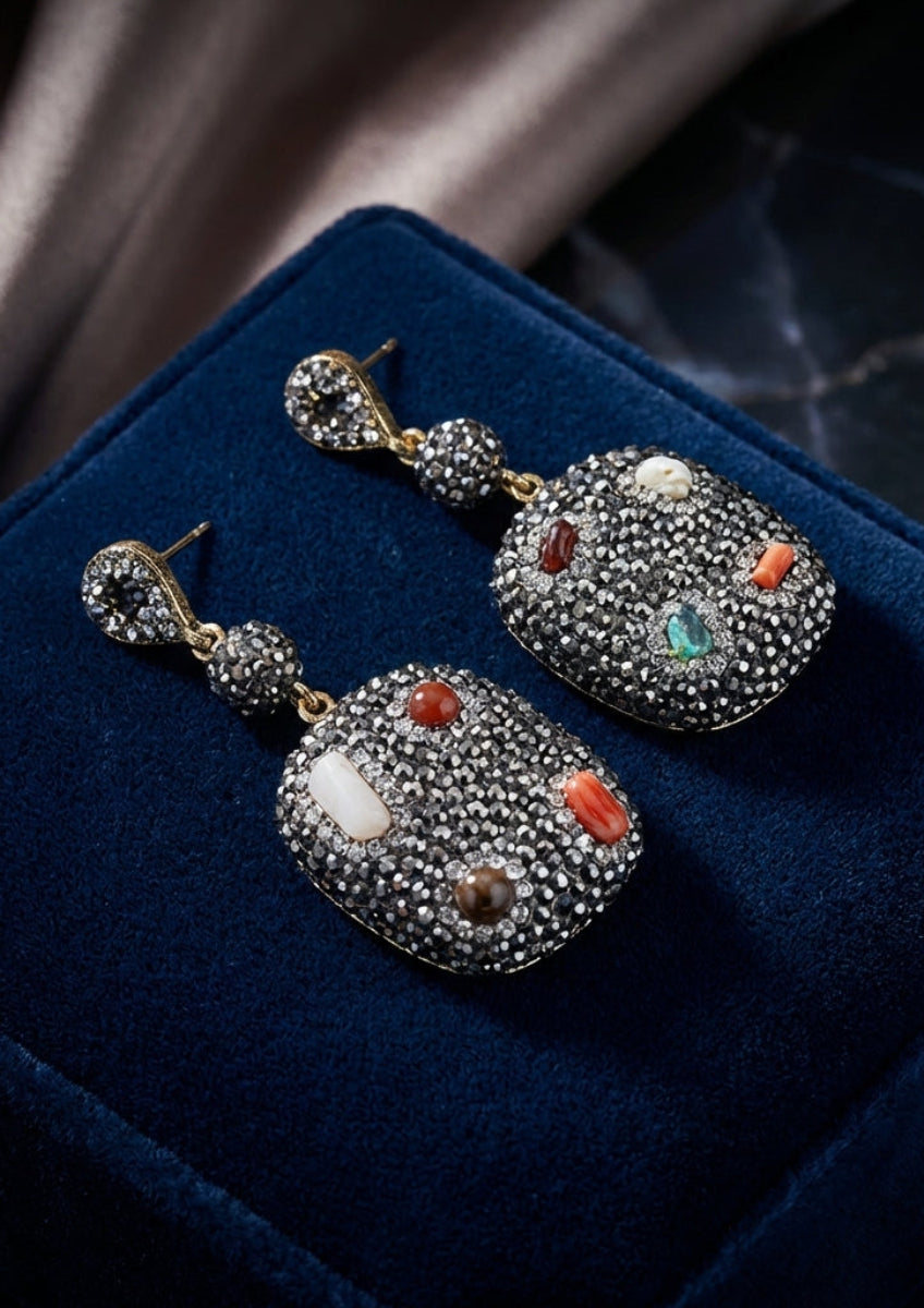 Decorative earrings on a blue velvet surface