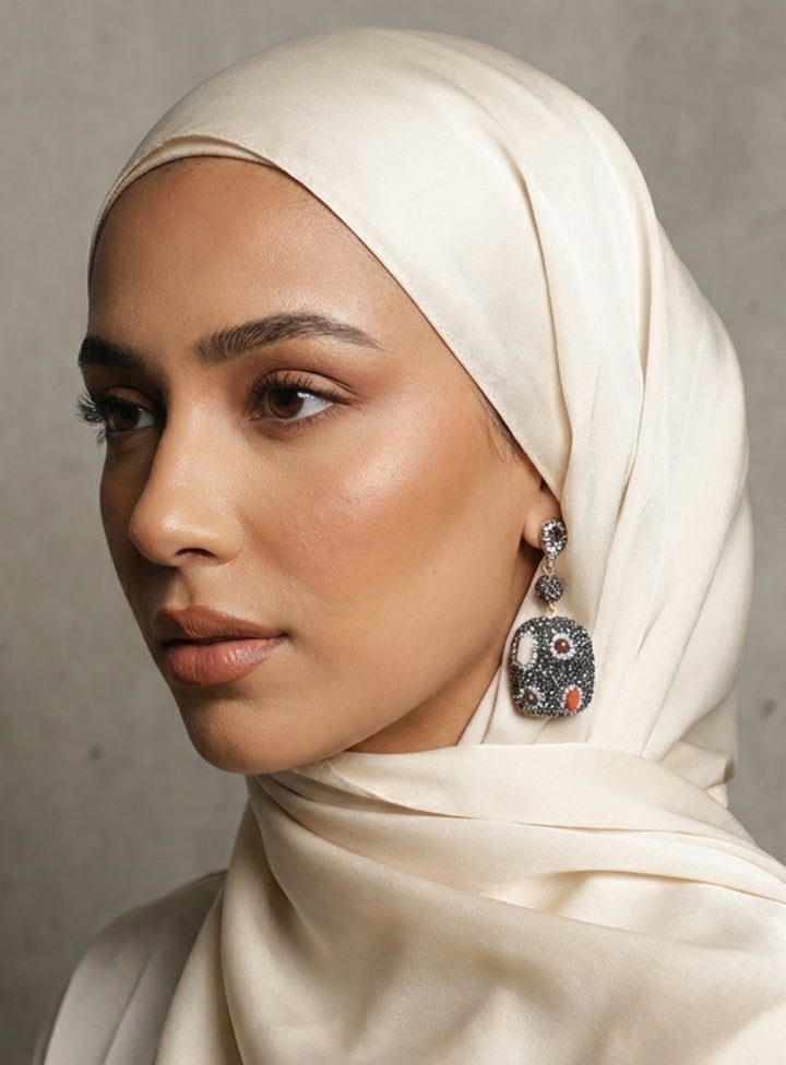 Woman wearing a beige hijab with a neutral background