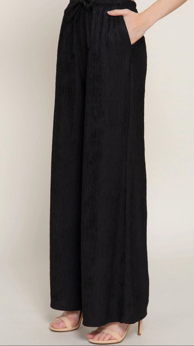 Black wide-leg pants worn by a person on a plain background