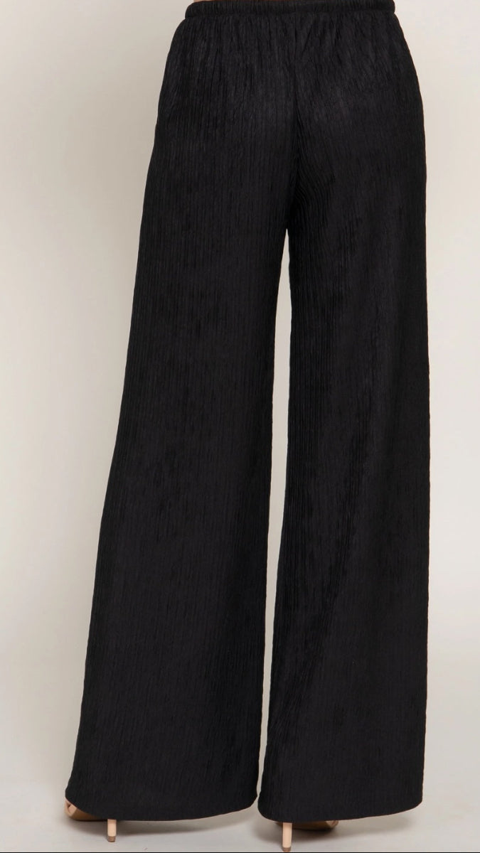 Black wide-leg pants on a plain background