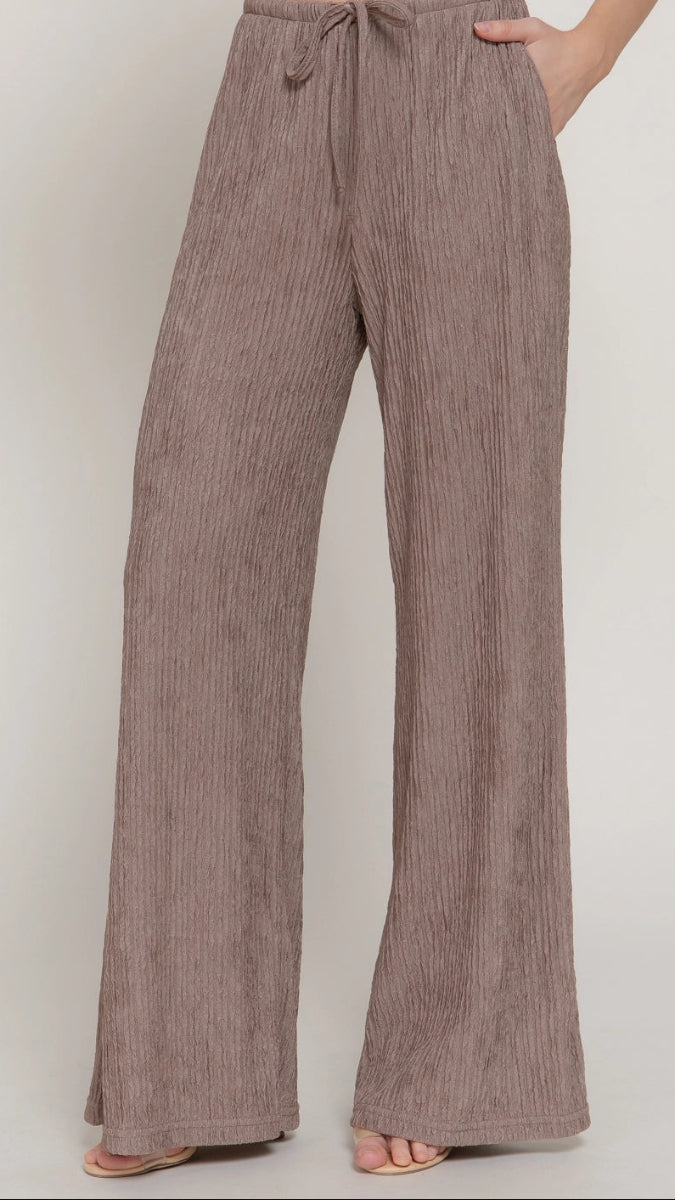 Brown striped pants worn by a person on a plain background