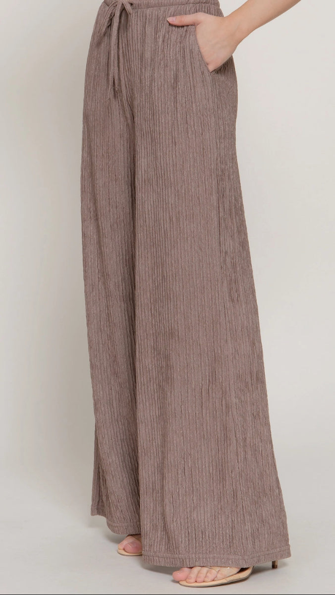 Brown wide-leg pants worn by a person on a white background