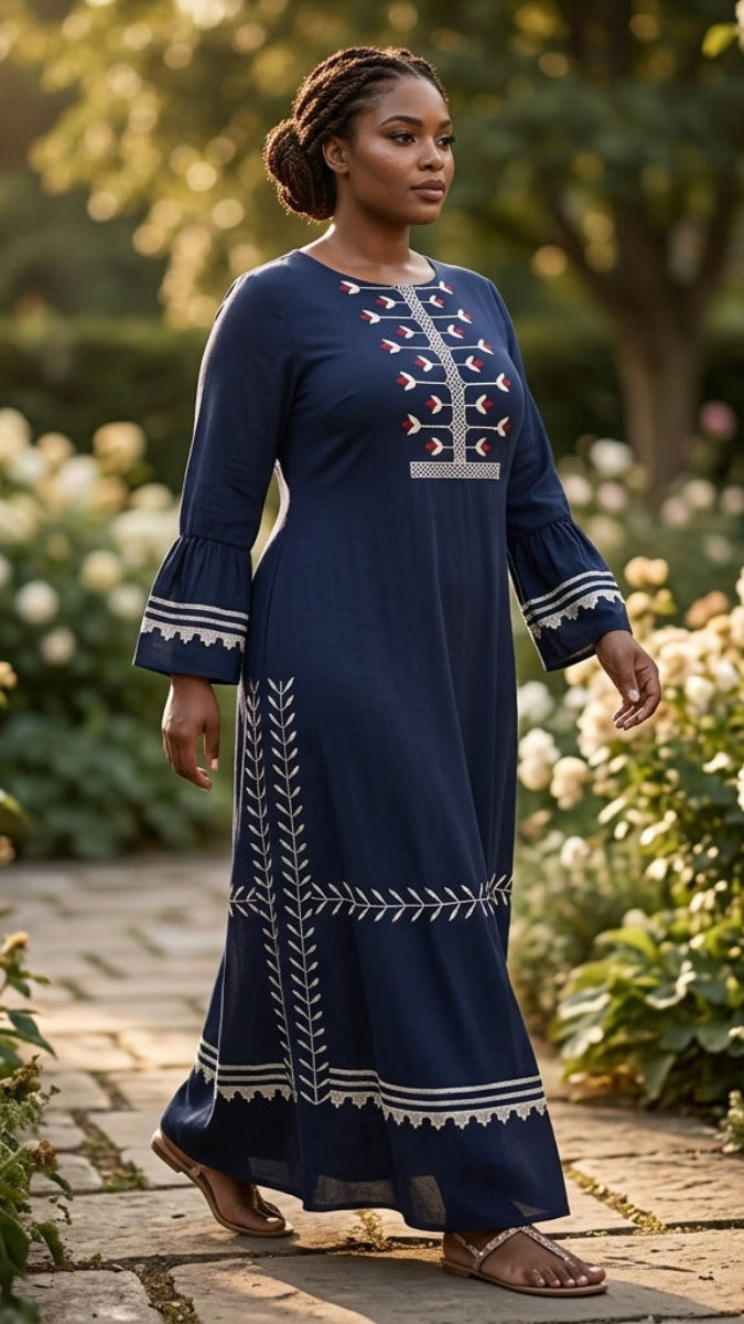 Woman in a blue dress with white patterns standing in a garden.
