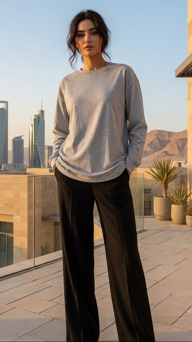 Woman standing on a rooftop terrace with city skyline in the background