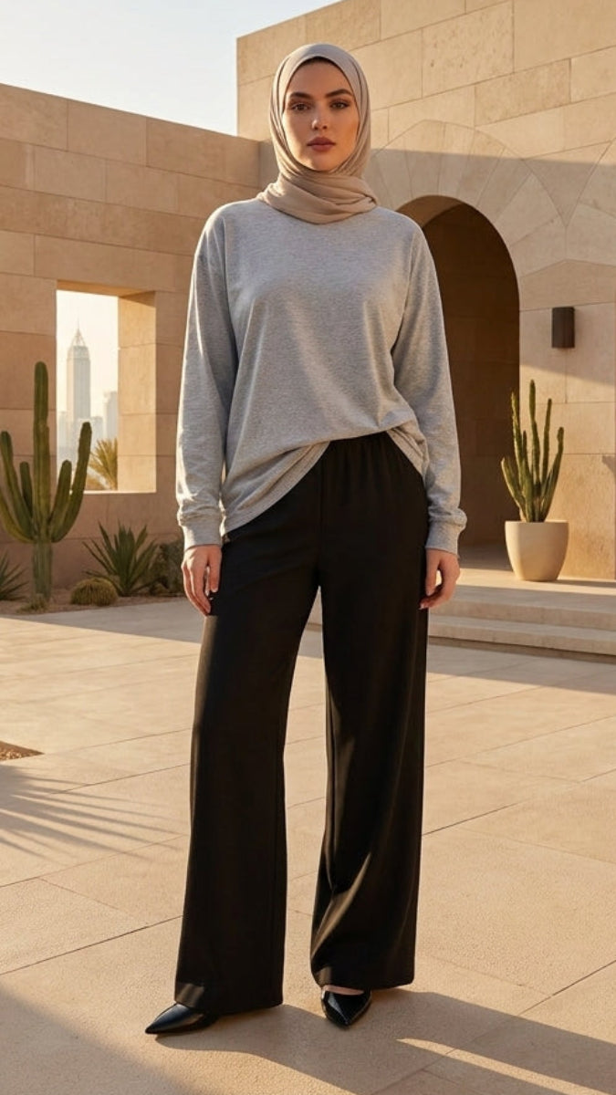 Woman in hijab standing in front of a stone building with cacti around