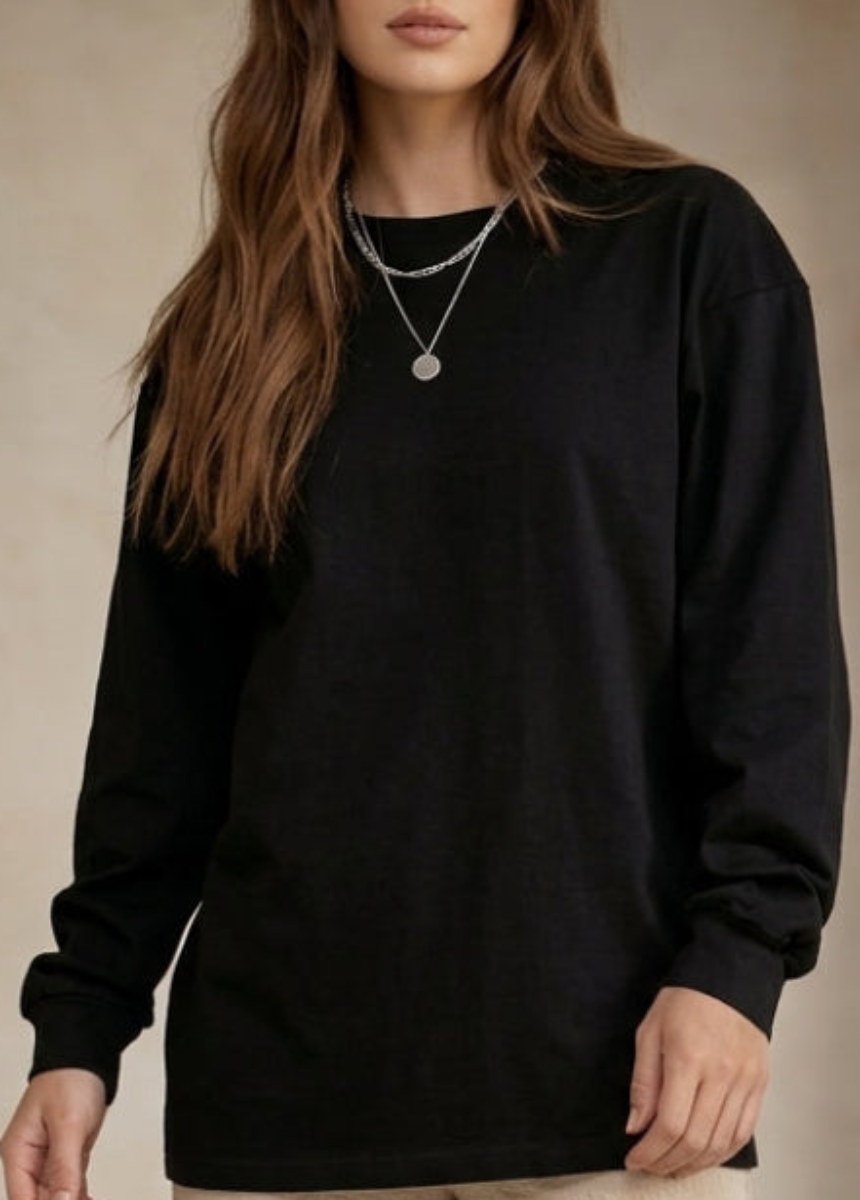 Person wearing a black long-sleeve shirt with a neutral background