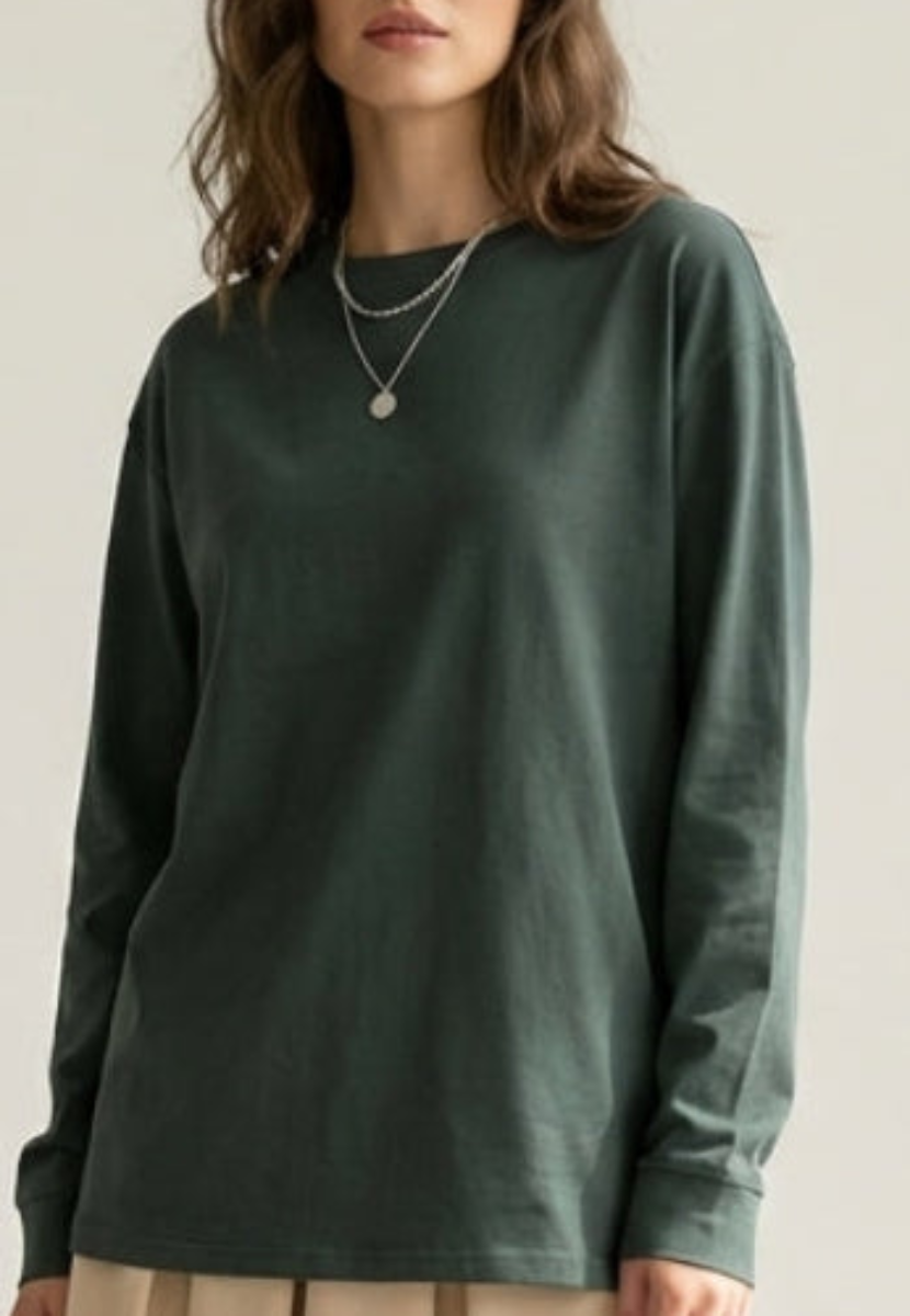 Person wearing a green long-sleeve shirt against a plain background
