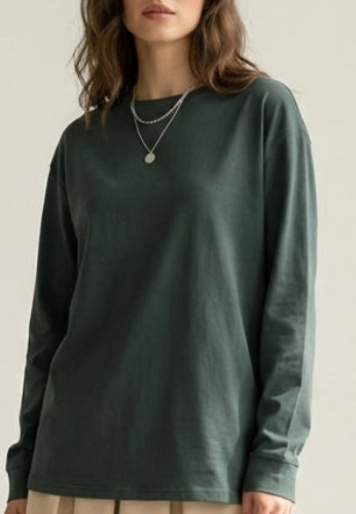 Person wearing a green long-sleeve shirt against a plain background