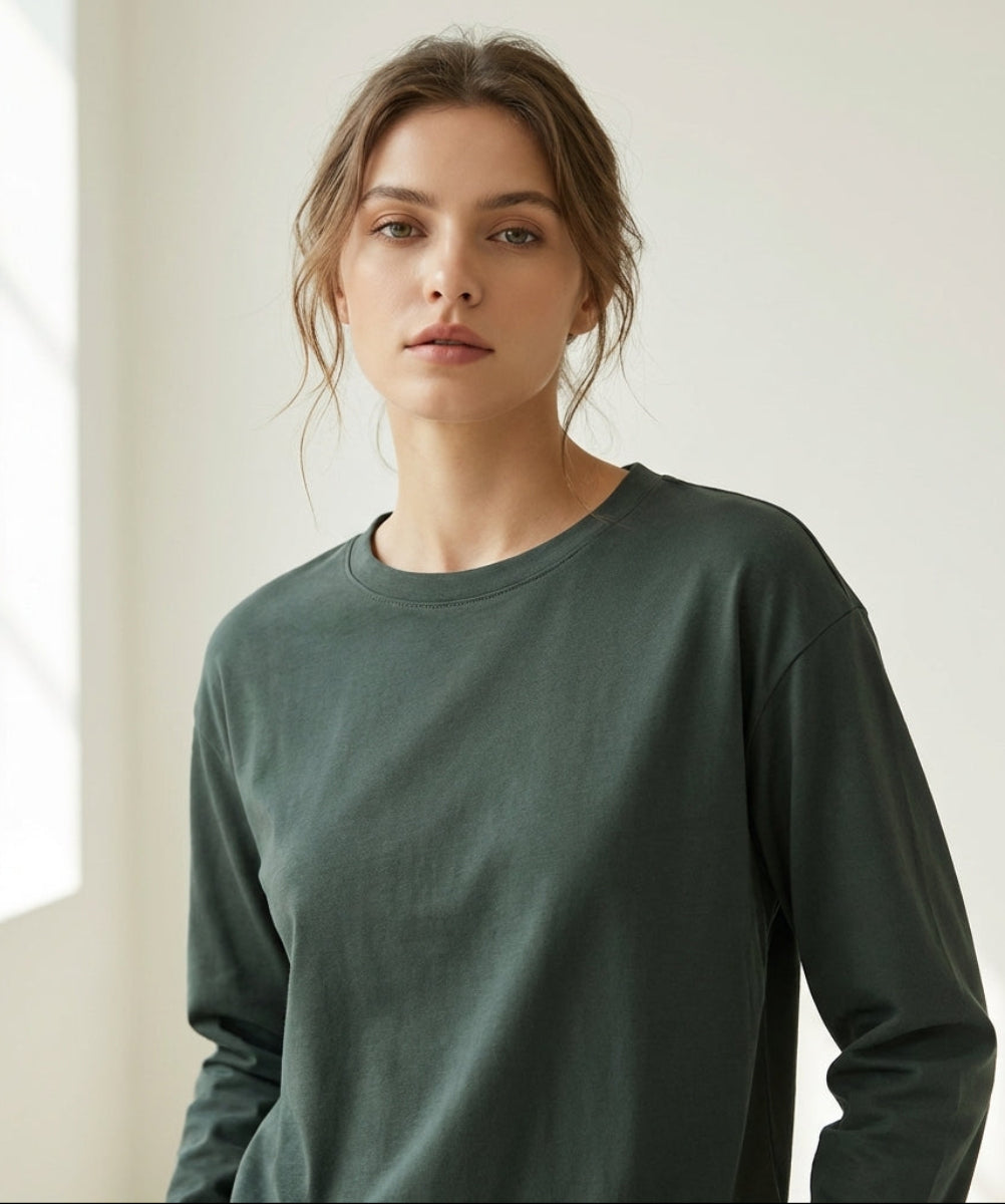 Woman wearing a green long-sleeve shirt in a bright room