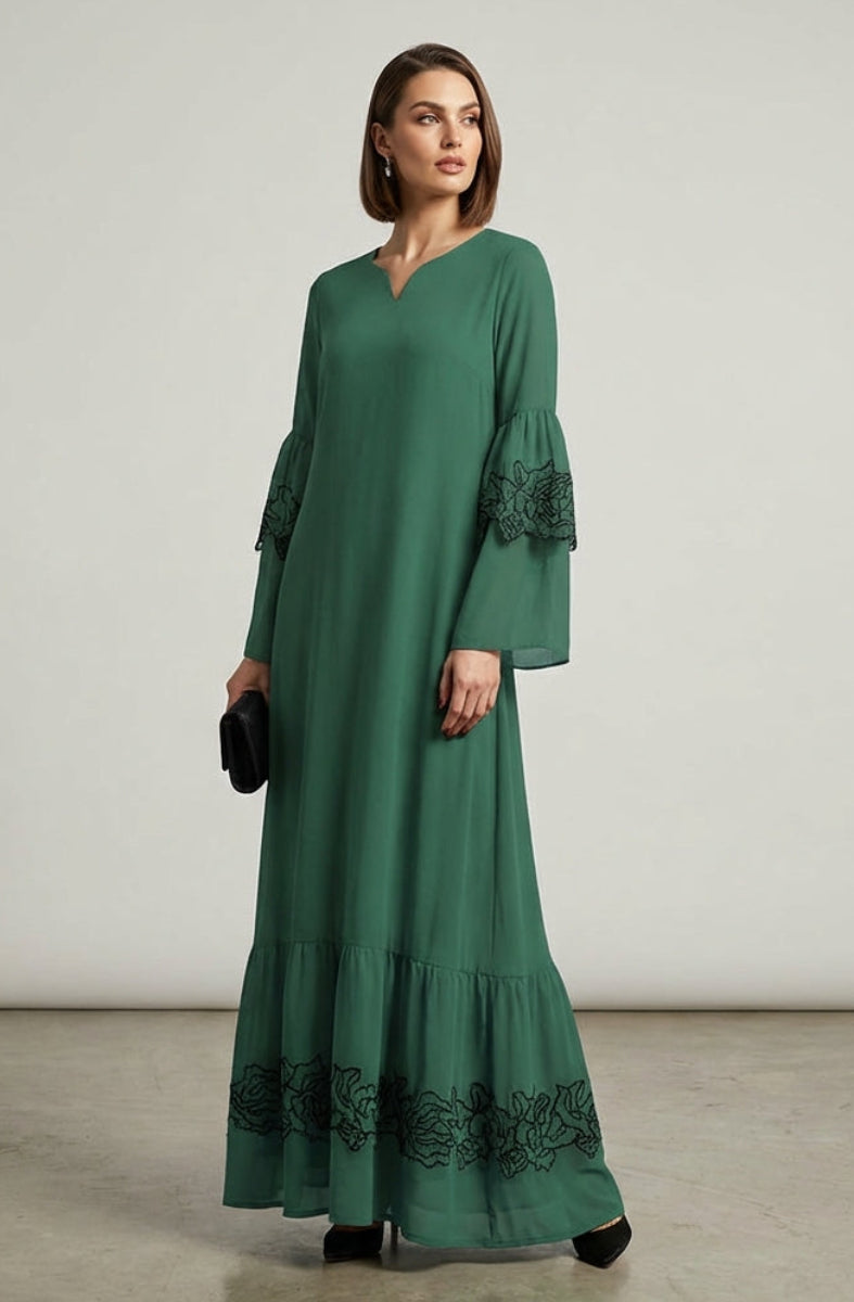 Woman wearing a green dress with lace details on a plain background